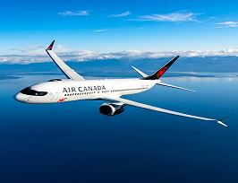 An Air Canada plane flying against a backdrop of fluffy clouds